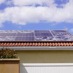 Solar panels on spanish tile roof with white spots of broken glass damaged from hailstorm. 