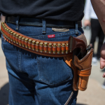 Person carrying gun and ammunition on holster at a counter-protest in response to protesters opposing the NRA's annual convention on Saturday, May 5, 2018 in Dallas, Texas.