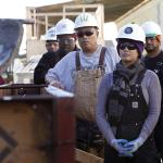 Students Marie Rowena Hall (right), Ryan Tagle (middle), and Michael Wells (left) learn how to work with concrete at JobTrain during laborers construction fundamentals training in Menlo Park, California.