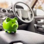 Green piggy bank money box in car interior, vehicle purchase, insurance or driving and motoring cost