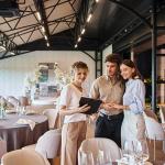 A couple engaging in a discussion with a wedding coordinator inside a wedding venue.