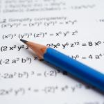 Blue pencil rests on page of algebra math problems. 