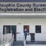 A voter places her absentee ballot in a monitored drop box in Dauphin County, PA.