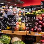 Grocery store prices in a New York store show apples and melons at high prices.