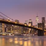 Brooklyn Bridge and Lower Manhattan skyline at dawn in New York City.