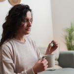Woman holding pipette of medical cannabis oil.