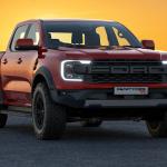 A red 2023 Ford Ranger Raptor with the sun setting in the background.