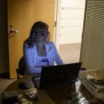 Election clerk working in a dark office on a computer.