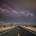 A starry night sky and road lines in a death valley desert in California, USA.