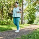 A senior black woman enjoying a morning run in a park.