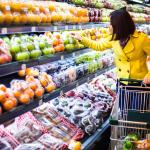 A woman shopping at the fruits section of a supermarket.