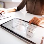 Invoice processing using a laptop and a separate digital tablet.