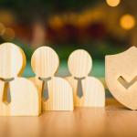 Wooden symbols for employees and a shield for insurance.
