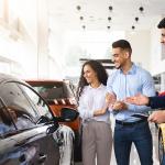 Couple looking into purchasing a car in a dealer.
