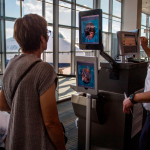 A woman using facial recognition verification at an airport.