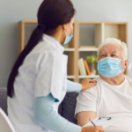 A health worker visiting a senior male patient at home.