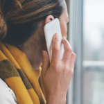 A woman on a phone call looking out a window.