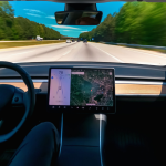 An interior view of a Tesla driving down a highway.