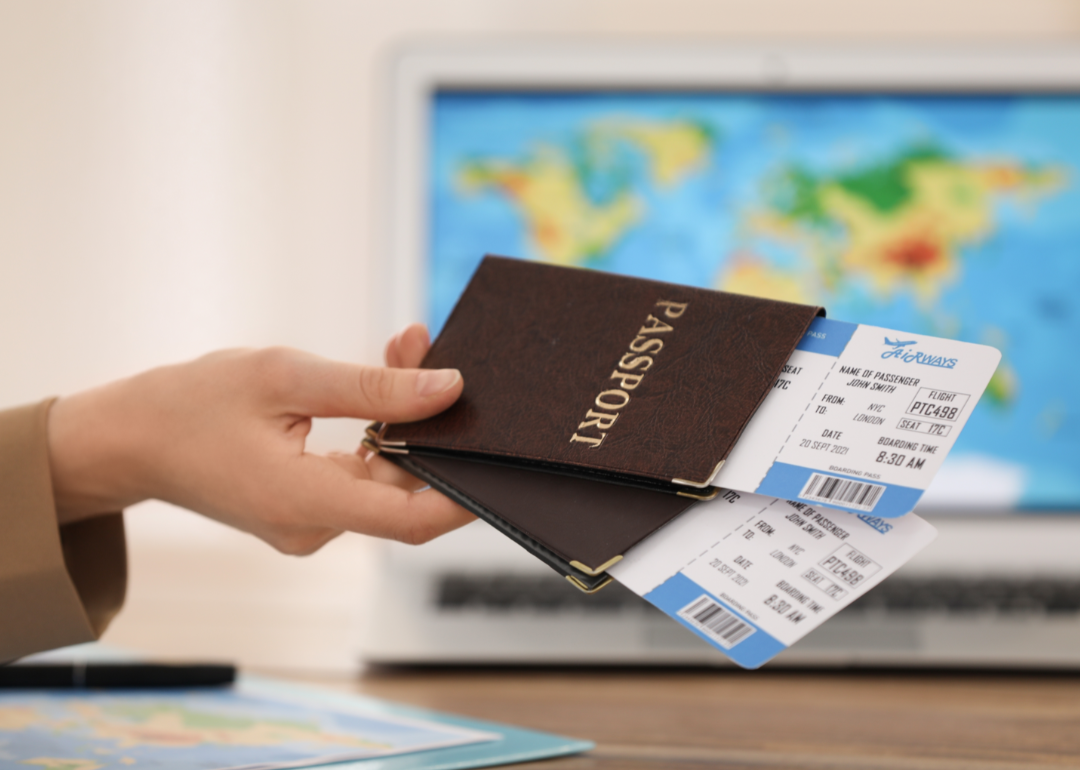 A travel agents hands over passports and tickets to a customer