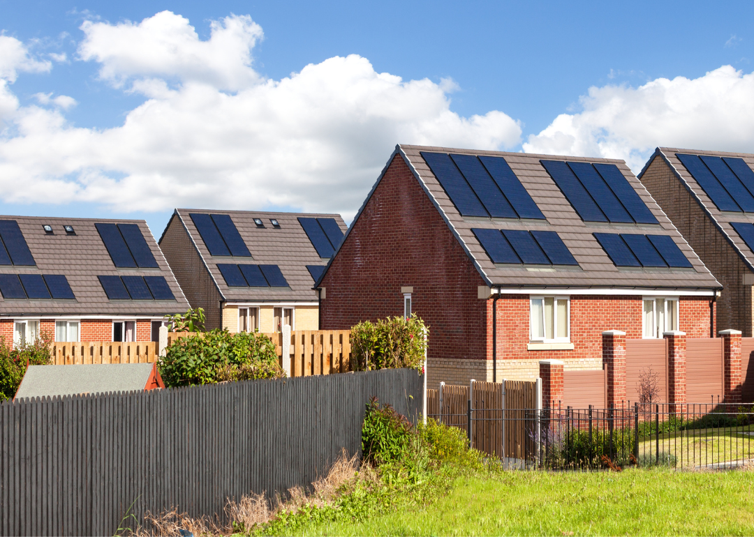 A row of new construction, brick homes that all have solar panels.
