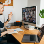 A young man having an onboarding video call in his home office