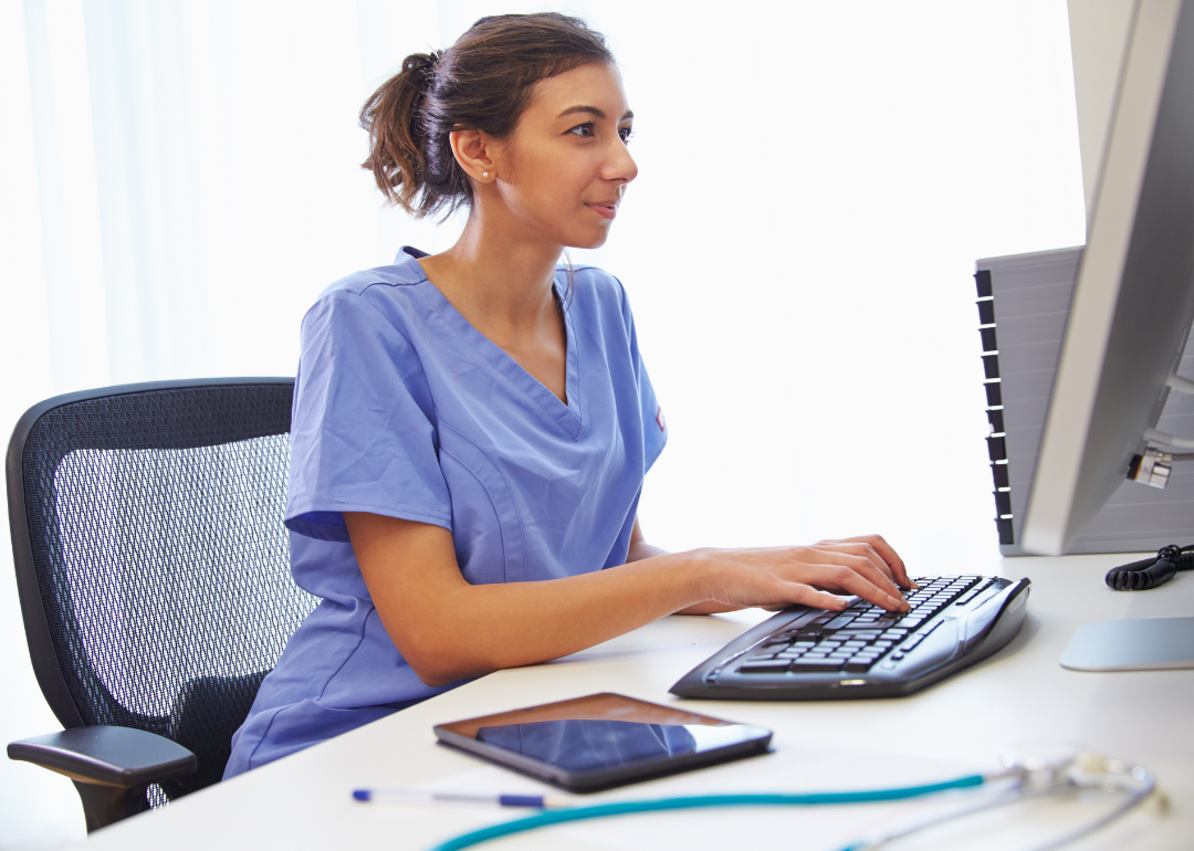 A doctor entering patient data into their computer.