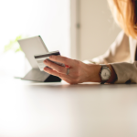 A woman typing in her credit card details while online shopping