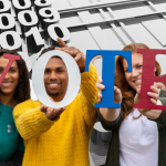 People hold up letters spelling out VOTE.