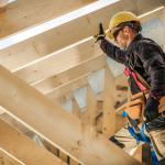 Construction worker on duty standing on wooden frame.