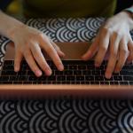 Close up top view of two hands on laptop keyboard