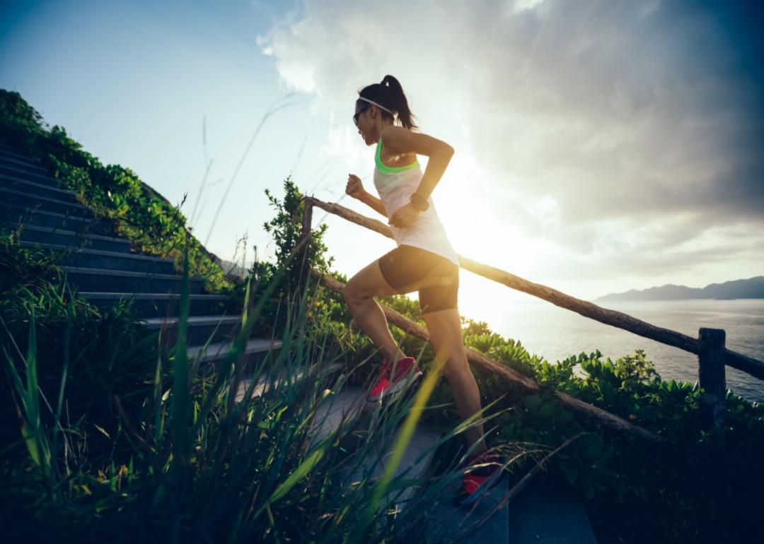 A woman running up outdoor stairs.