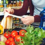 Person shopping at the grocery store with cart.