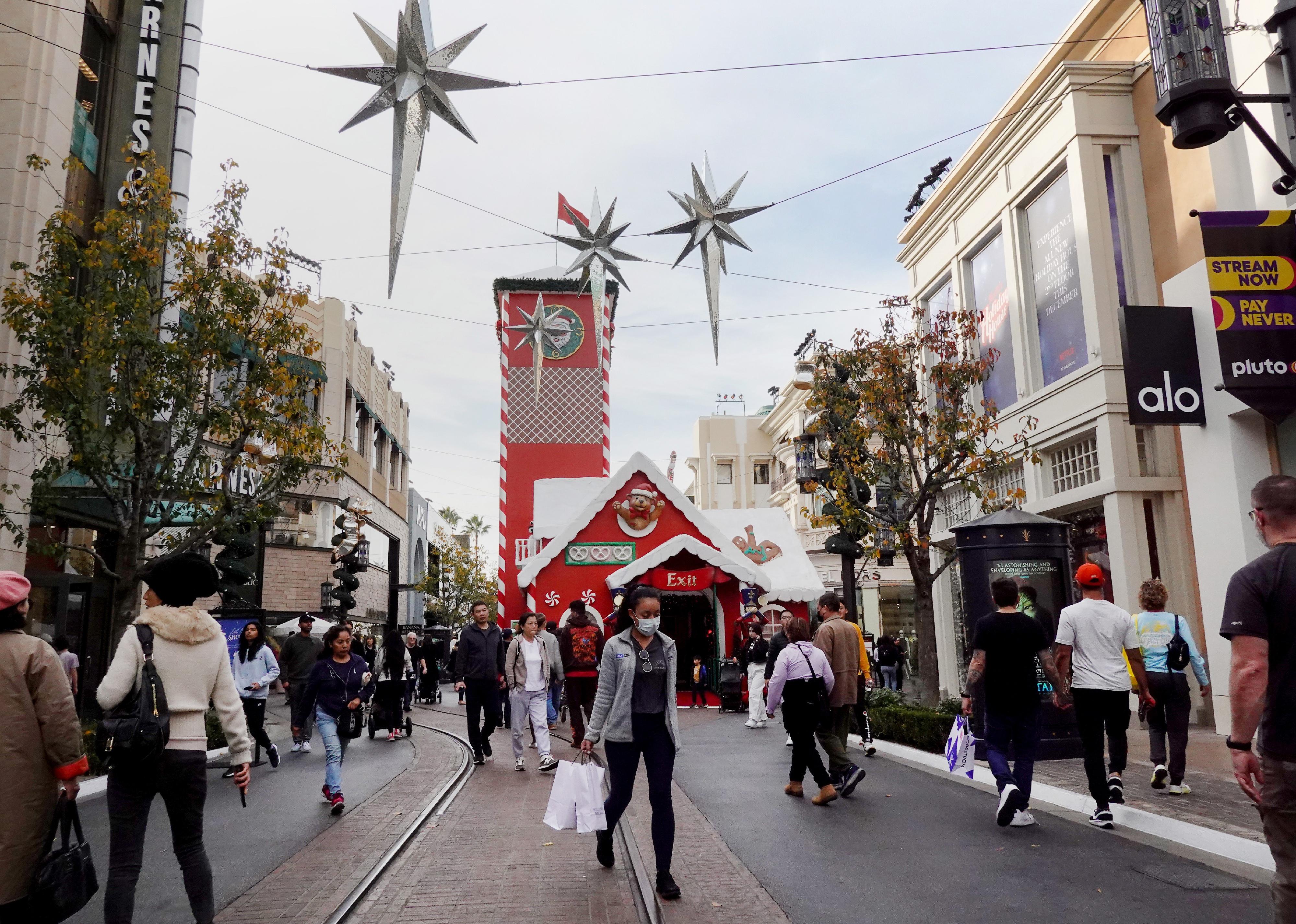Shoppers at an outdoor mall at Christmas time.