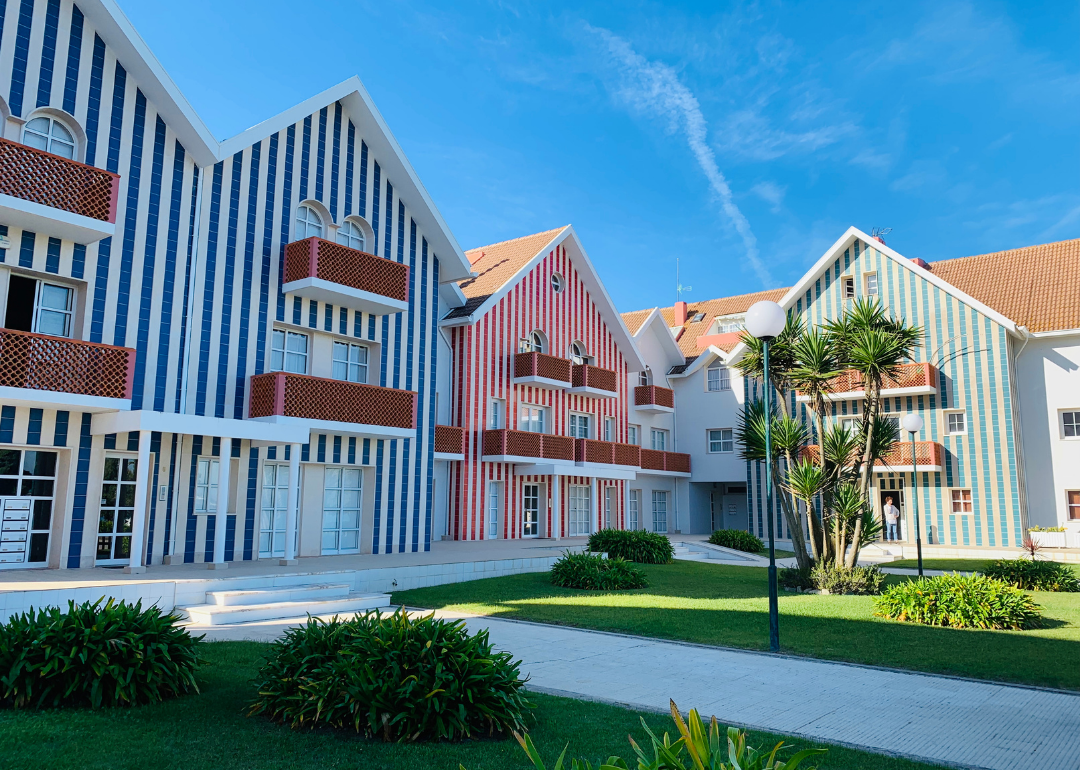 Modern striped townhomes with green grass in front.