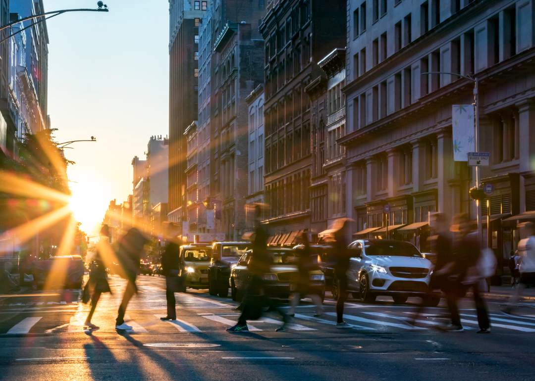 Blurry people moving quickly through a crosswalk in New York City.