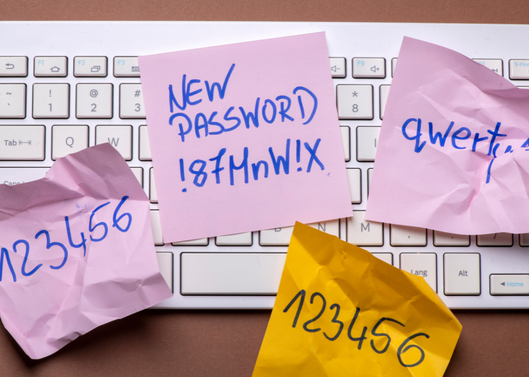 Keyboard with post-it notes showing scribbled passwords.