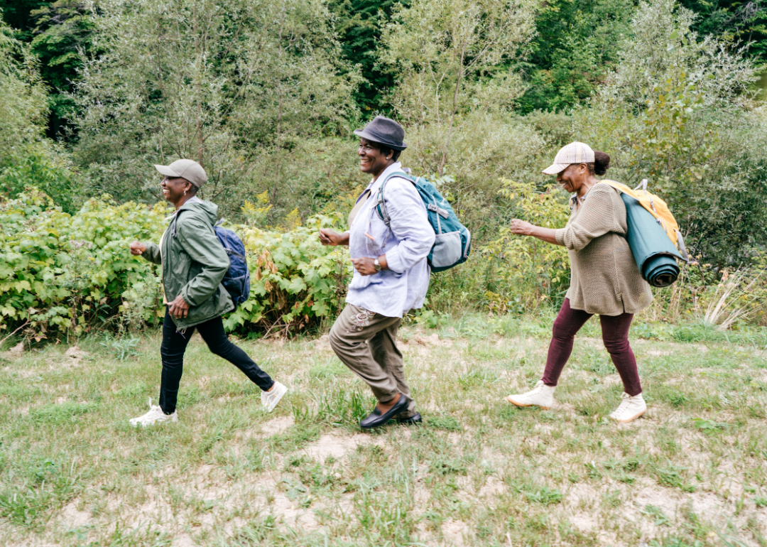 Three older women hiking in a line.