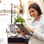 Female with tablet behind sales desk of florist store