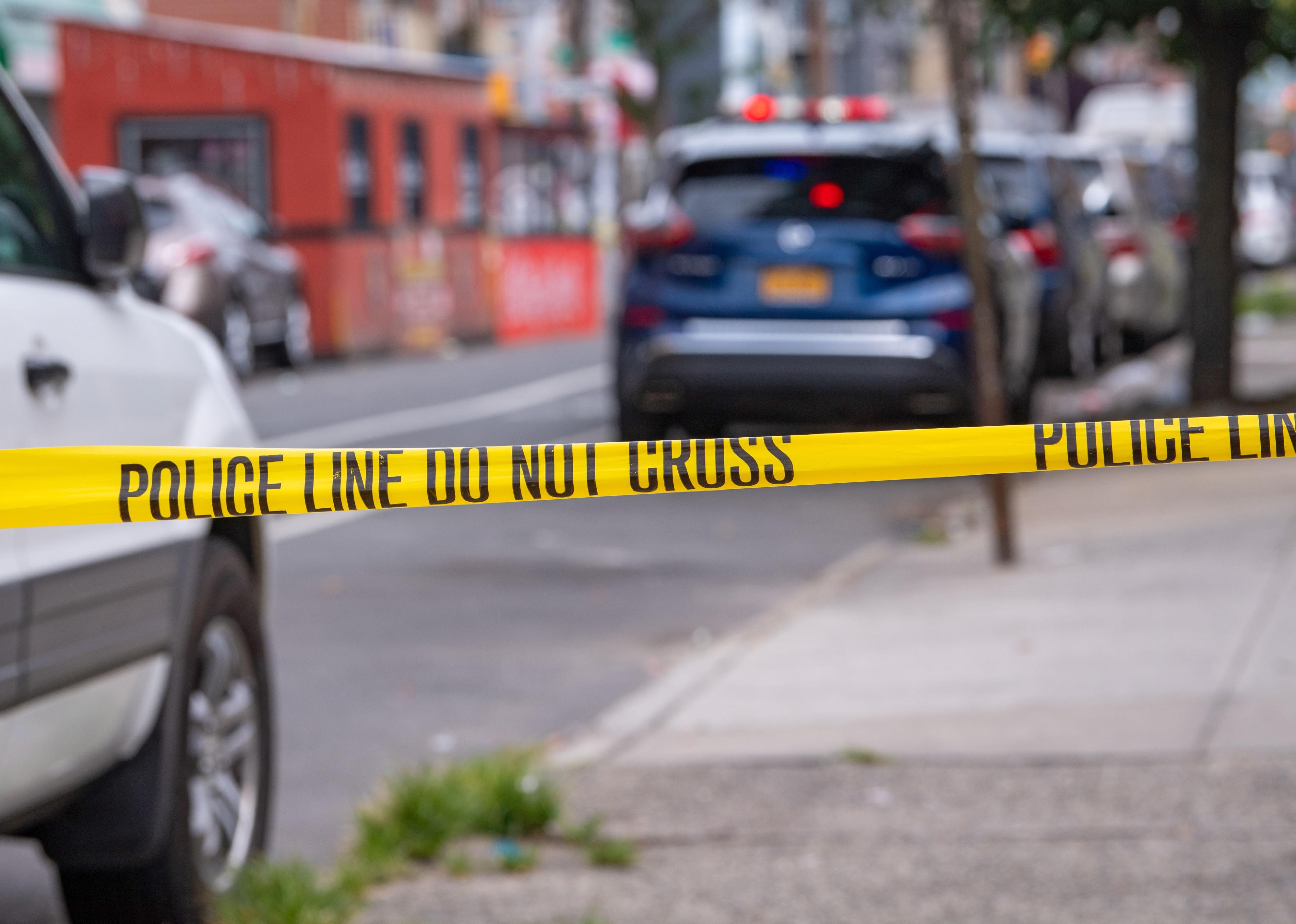 Crime scene tape on a sidewalk.
