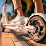 Close-up image of a person's feet on an electric scooter.