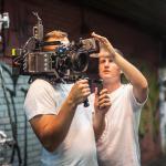 Two cameramen shooting a scene on outdoor set