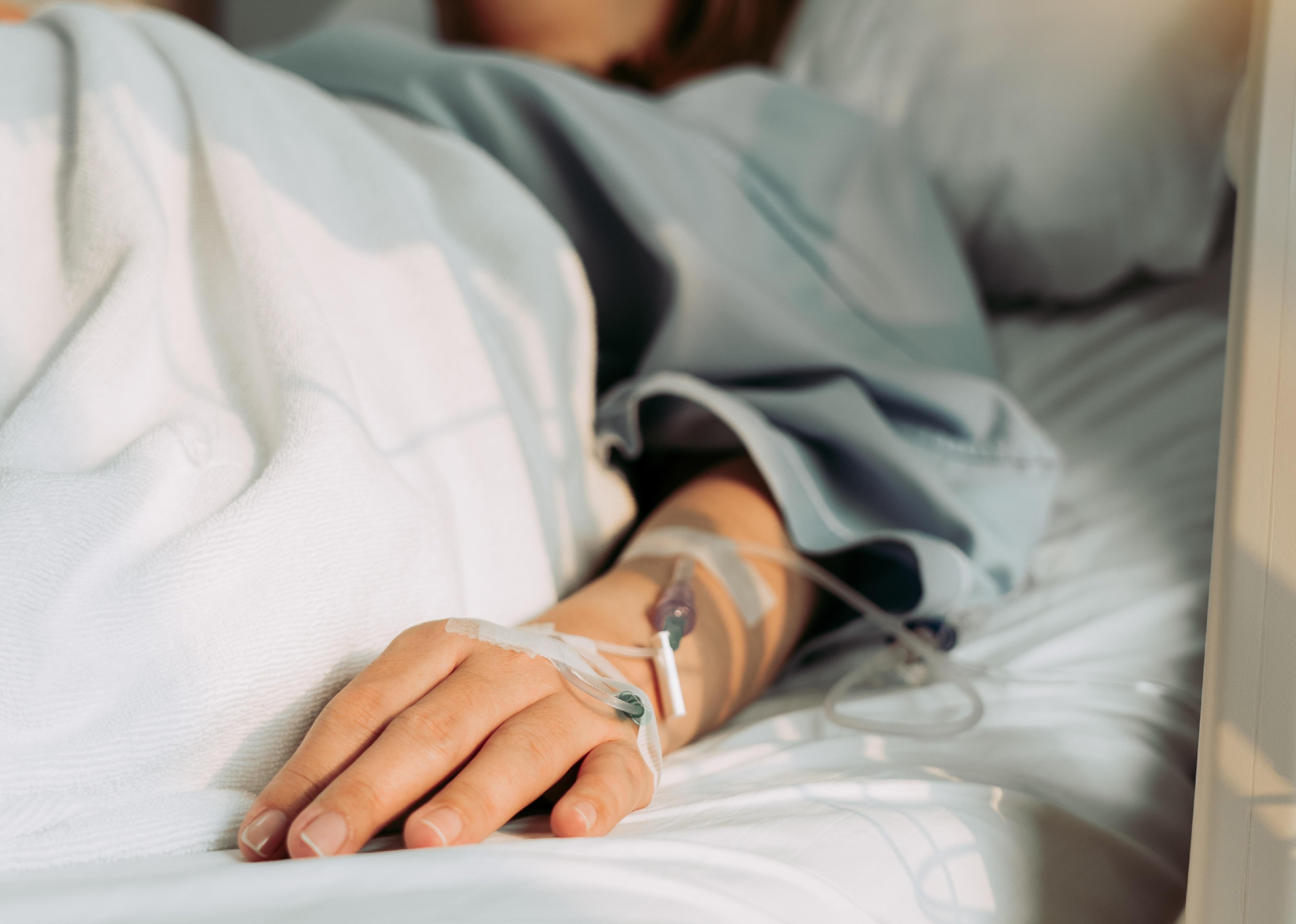 Person lying in hospital bed.