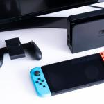 Nintendo Switch video game console next to the TV in a home living room.