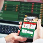 Businessman using smartphone with gambling app.