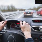 Close-up of hands on a steering wheel.