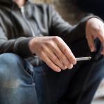 Close up of young man smoking cigarette outdoors