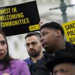 People hold signs in support of sanctuary city mayors outside the U.S. capitol, on Wednesday, March 5, 2025 in Washington, D.C.