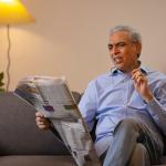 Senior man reading a newspaper in confusion.