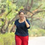 A middle-aged woman jogging at the park.