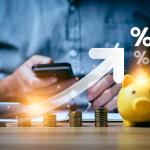 A business professional calculating and saving finances illustrated with increasing interest rates graphics.